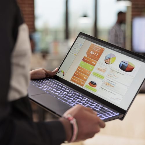 employee holding laptop with business diagrams